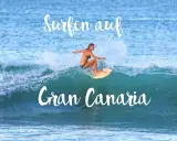 Surfen auf Gran Canaria: Eine Frau surft auf einer Welle, umgeben von Gischt.