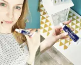 Kobieta trzyma tubkę maści ichtiolowej.