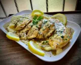 Delicioso pollo al limón con puré de patatas, adornado con rodajas de limón y perejil fresco.