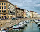 Edifici storici e barche ormeggiate lungo il canale del **terminal crociere Livorno**.