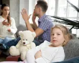 Smutna dziewczynka z misiem, podczas gdy jej rodzice się kłócą. Mąż wyprowadził się z domu, a rozwód jest nieunikniony.