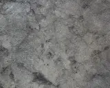 Textura rugosa y desigual de hormigón gris, con zonas más oscuras que sugieren desgaste o humedad.
