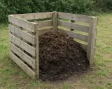 Drewniany kompostownik wypełniony ziemią i resztkami organicznymi. Prosty sposób, jak zrobić kompostownik w ziemi.