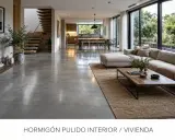 Amplio salón moderno con suelo de hormigón pulido, sofá modular, mesa de centro de madera y escaleras flotantes.