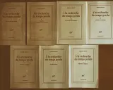 Una collezione di volumi di "Alla ricerca del tempo perduto" di Marcel Proust, editi da Gallimard, disposti su uno sfondo marrone.