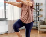 Frau macht Oberschenkel Training ohne Kniebelastung. Sie steht auf einem Bein, das andere angewinkelt.