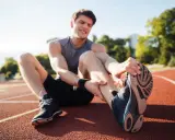 Zawodnik na bieżni z bólem nogi, potrzebuje fizjoterapii sportowej.