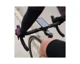 Rowerzysta trzyma kierownicę, na której zamontowano telefon za pomocą uchwytu sp connect. Na ekranie widoczny czas i prędkość.