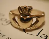 Złoty pierścionek z sercem, dłońmi i koroną – celtycki symbol miłości, symbolizujący wierność i przyjaźń.