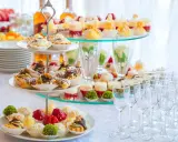 Un buffet de hors d'œuvre varié avec des mini-tartes, des éclairs au chocolat et des fruits frais, prêt à ravir les invités.