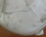 Patrones de sábanas para cochecito de bebé hechas a mano con lunares rosados y borde de encaje.