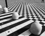 Massi ovali su pavimento a scacchi, un gioco di prospettiva e ombre. #streetphotography
