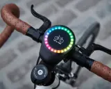 Nowy, okrągły wyświetlacz na kierownicy roweru z tęczowym podświetleniem i napisem "Let's ride!". Idealny do pomiaru prędkości, dystansu i innych parametrów, jak sigma rozmiar koła.