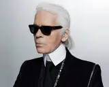 Ikona stylu, Karl Lagerfeld, w czarnym garniturze i okularach. Kto to? Ikona mody.