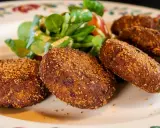 Crocchette dorate e croccanti, un classico su cosa mangiare in Lombardia, servite con un'insalatina fresca.