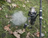Plątanina żyłki wędkarskiej obok kołowrotka. Wygląda jakby peknieta zylka spowodowała taki bałagan.
