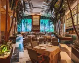 Tropische Atmosphäre in einem der Restaurants in Valencia. Palmen und ein Wasserfall-Bild im Hintergrund schaffen ein einzigartiges Ambiente.