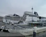Donna in piedi davanti a due navi MSC in attesa dell'imbarco a Genova per Portofino.