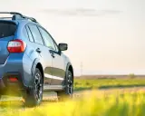 Niebieski SUV na tle pola. Chcesz wiedzieć, jak sprawdzić zniżki OC?