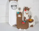 Un grupo de adorables llamas amigurumi, hechas a mano con lana, posan juntas.