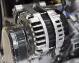 Błyszczący alternator w aucie, kluczowy element układu elektrycznego, gotowy do ładowania akumulatora.