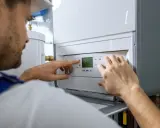 Un technicien ajuste les réglages d'une chaudière fioul qui démarre puis s'arrête.