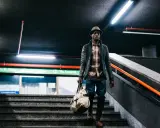 Uomo con borsa scende le scale di una metropolitana, un'immagine con un'atmosfera urbana e moderna. Queste foto creative catturano momenti di vita quotidiana.