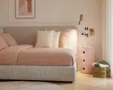 Camera da letto ragazza aesthetic: letto accogliente con biancheria a quadretti, cuscini morbidi, comodino rosa e decorazioni murali.
