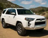 Un blanco SUV listo para la aventura, con sus robustas ruedas preparadas para conquistar caminos de montaña.