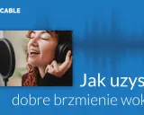Kobieta z mikrofonem i słuchawkami śpiewa, dążąc do doskonałego brzmienia wokalu.