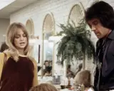 Goldie Hawn och Warren Beatty i en scen från en film. Hon har blont hår och en gul och brun tröja. Han har mörkt hår och en mörk skjorta.
