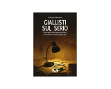 Copertina del libro "Giallisti sul serio" di Giuseppe Battarino, con una lampada da tavolo accesa su fogli sparsi, occhiali e una penna. Un omaggio ai giallisti italiani.