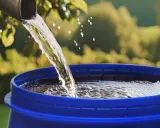 Un tubo gris vierte agua clara en un barril azul, demostrando cómo canalizar agua de lluvia para su reutilización.