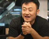 Ben Zhou, w czarnej koszulce, z dłońmi złożonymi na piersi, opowiada o przyszłości kryptowalut.