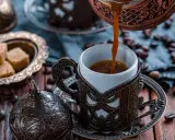 Heißer Mokka wird in eine verzierte Tasse gegossen. Der Unterschied zwischen Mokka und Espresso liegt in der Zubereitung und Intensität.