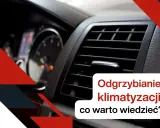 Widok na kratkę nawiewu klimatyzacji samochodowej i deskę rozdzielczą.