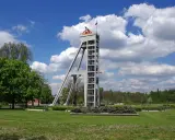 Betonowy szyb górniczy, dawniej szyb prezydent, góruje nad zielonym parkiem.