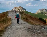 Wędrowiec idzie ścieżką ku czerwonym wierchom z Kuźnic.