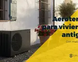 Unidad exterior de aerotermia junto a una casa antigua. ¿Son viables las mentiras de la aerotermia en viviendas antiguas con mala eficiencia?