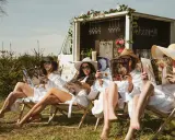 Relaks na świeżym powietrzu podczas wieczoru panieńskiego. Dziewczyny w szatach i kapeluszach czytają magazyny ślubne przy Prosecco Van.