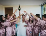 Novia y damas de honor brindan con champán, ¡ideas para despedidas llenas de alegría y celebración!
