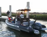 Bateau Zodiac prêt pour l'aventure, son hypalon garantissant une longue durée de vie. Famille à bord, profitant du coucher de soleil.