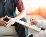 Lekarz notuje objawy pacjenta, który martwi się o swoją męską prostatę.