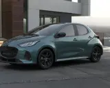 Elegancka, zielona Mazda 2 Hybrid stoi przed nowoczesnym domem.