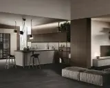 Cuisine en U ouverte sur salon, avec îlot central, tabourets et rangements intégrés. Ambiance moderne et épurée.