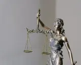 Figurka Temidy z wagą, symbol sprawiedliwości. Jej postawa sugeruje, że rozważa ona czynności przekraczające zwykły zarząd, szukając równowagi.