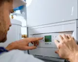 Técnico ajustando la temperatura en un calentador de gas butano. La pantalla digital muestra 30.0 grados.