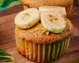 Pyszne muffinki bananowe fit z masłem orzechowym i plasterkami banana na drewnianej desce.