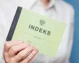 Zielony indeks, symbol studiów magisterskich w Łodzi, w dłoni studenta.