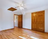 Habitación con suelo de madera clara y puertas de madera oscura, creando un contraste cálido.